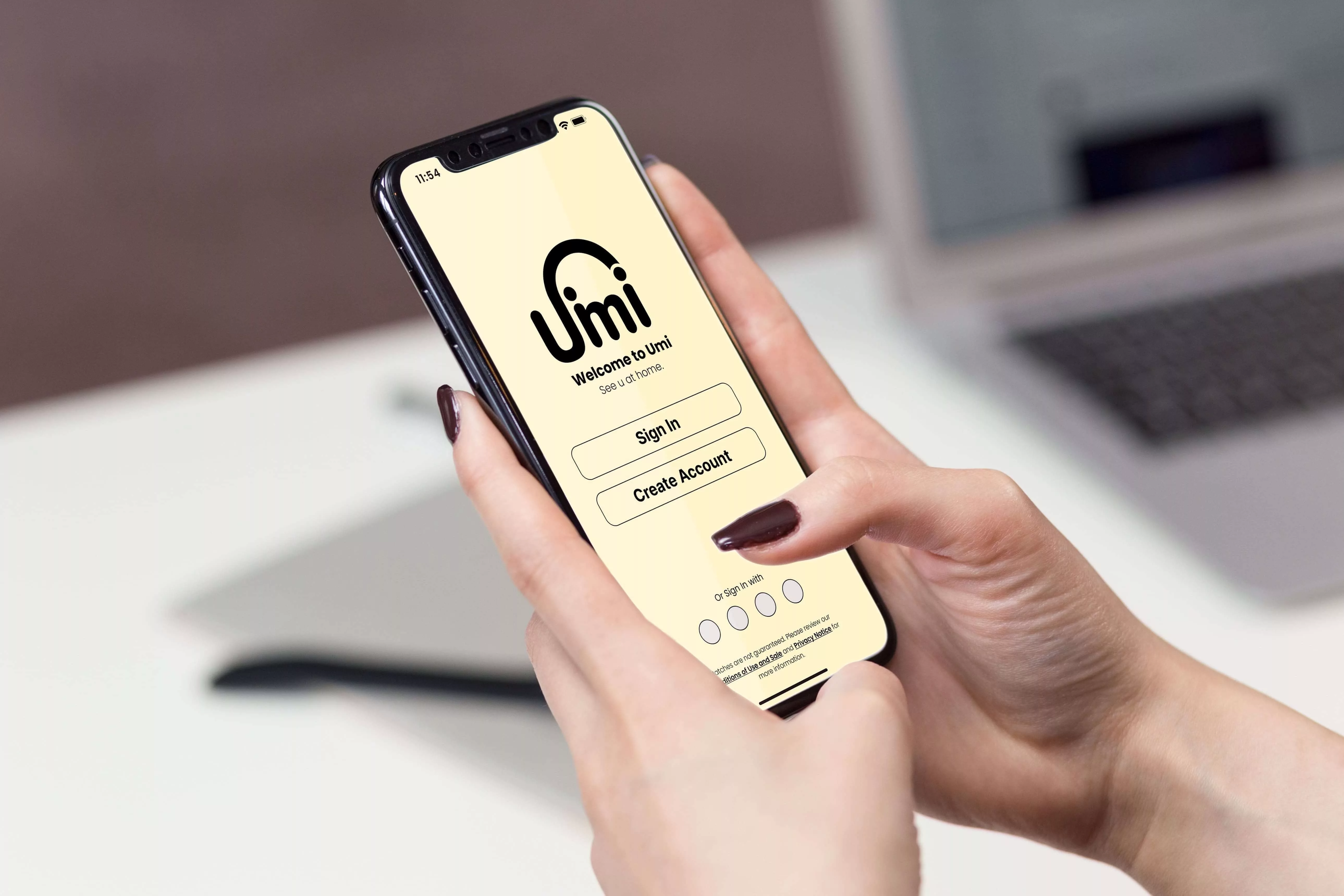 A hand holding a phone that has the Umi sign up screen.